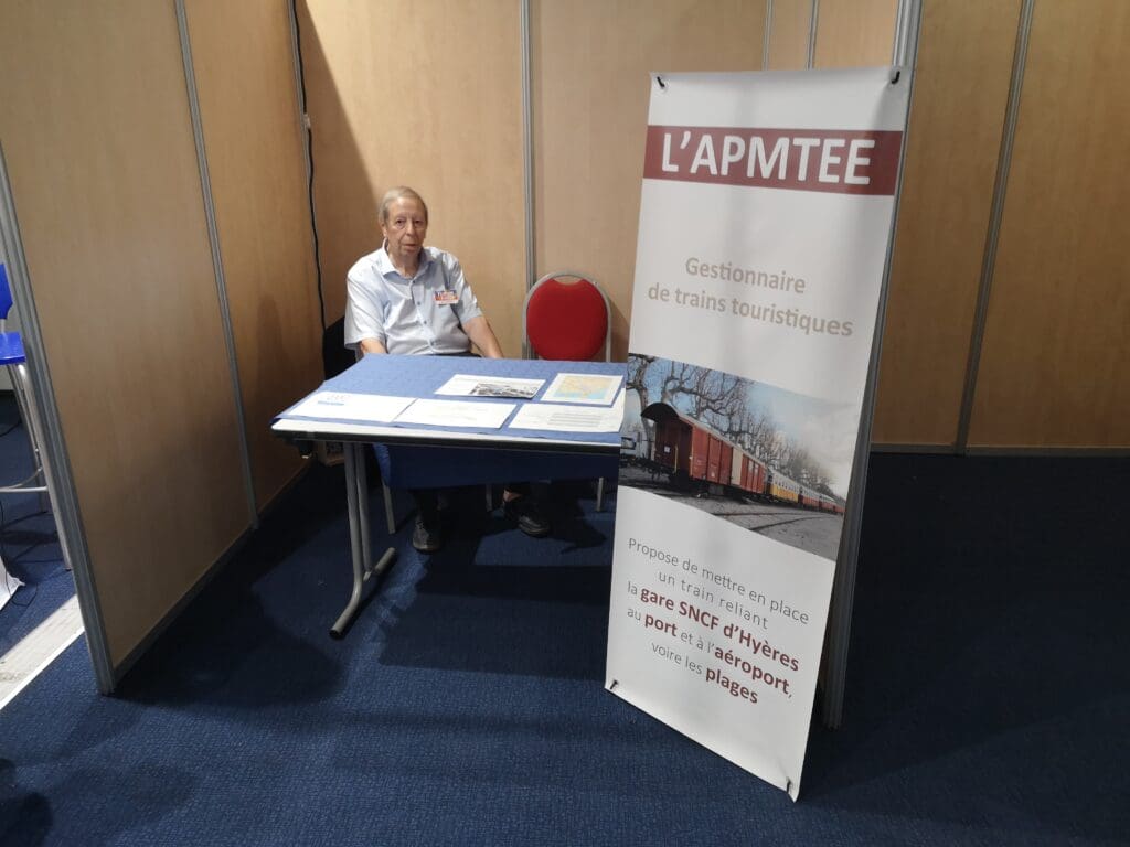 Photo du président tenant le stand de l'AHTF. Stand particulièrement épuré pour cette année 2025.